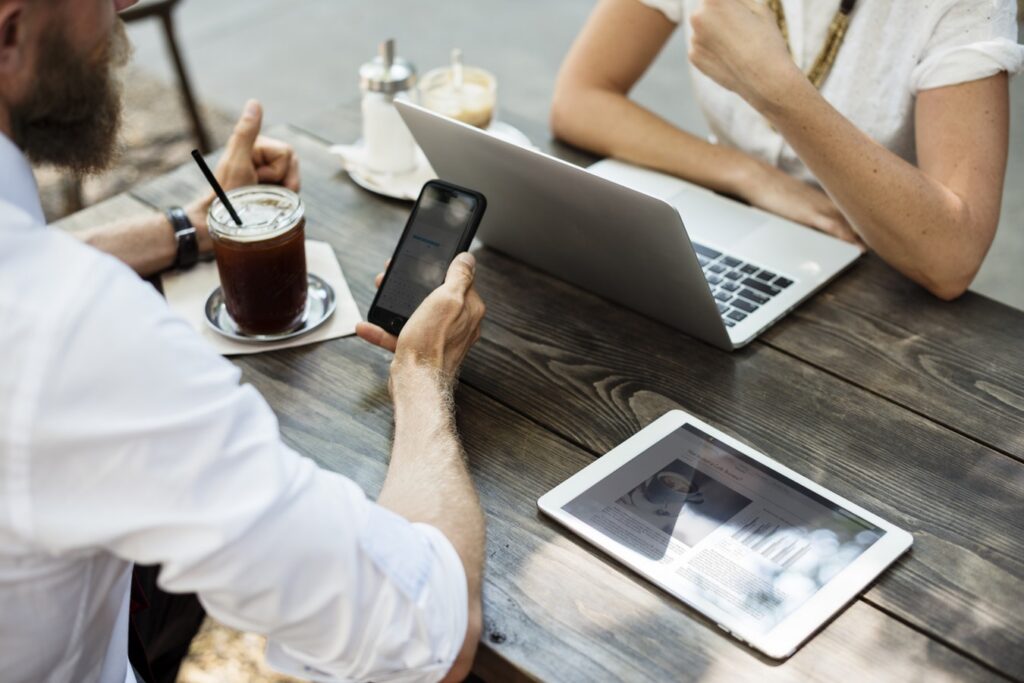couple working at computer looking at phone