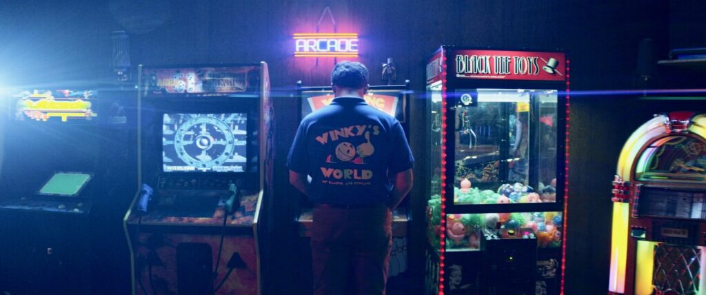 Man playing arcade game, seen from behind