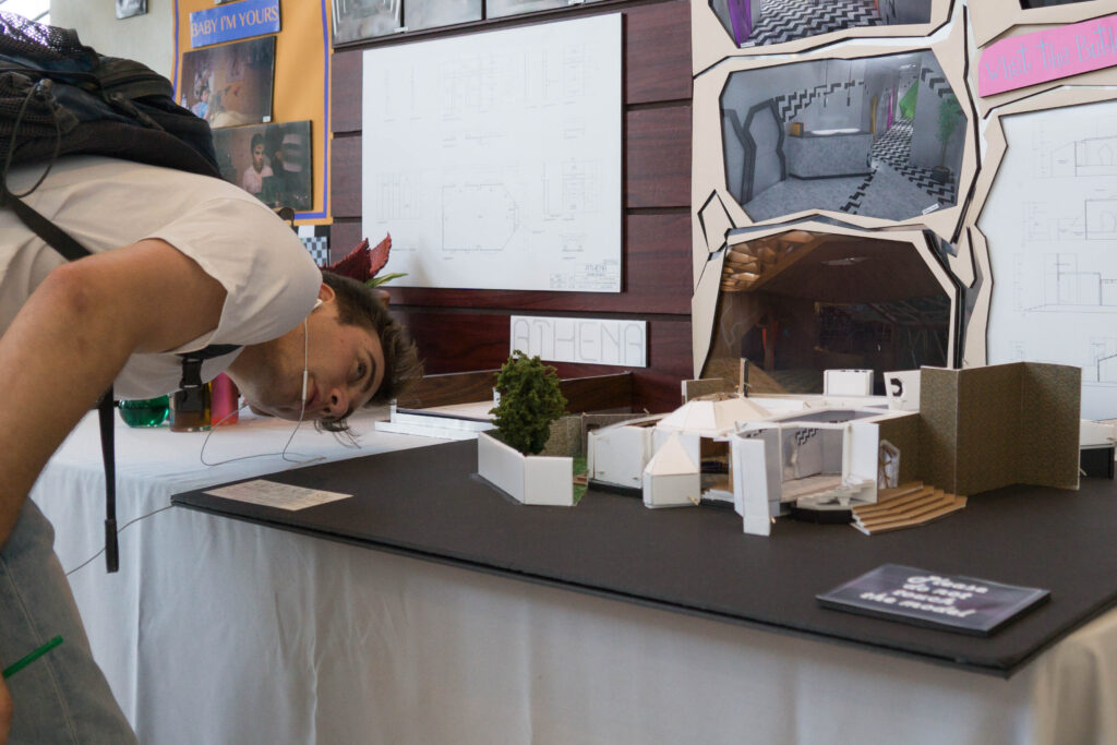 A visitor looks closely at the details of a miniature for the Production Design Showcase