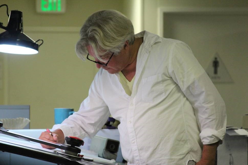 Professor John Chichester sketches at a table.