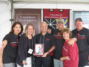 Group of people posing with man holding book.