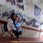 CES Students Kenia and Ashley on the steps of UNED's historical timeline mural.