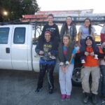 Students posing next to a truck.