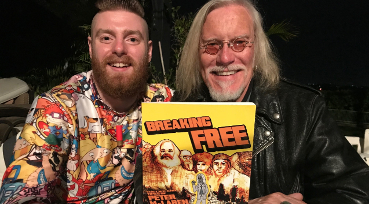 Miles Wilson and Peter McLaren sitting at a table holding their comic book Breaking Free