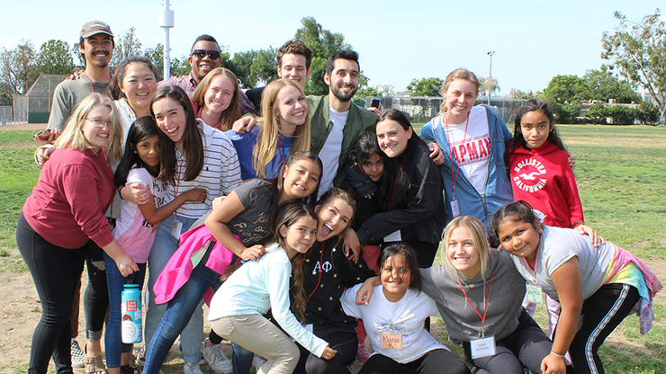 Group picture of Chapman students with Higher Ground kids