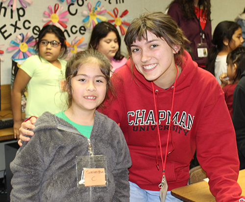 Chapman student with smiling Higher Ground girl