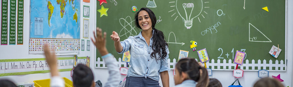 A teacher is leading a class of elementary school children.