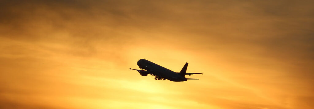 Airplane flying at sunset