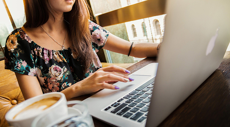 Young women with coffee and laptop