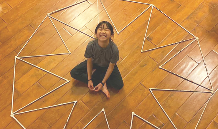 Child on the floor with homemade math structure