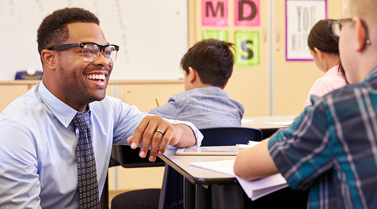 male teacher with young students in a classroom