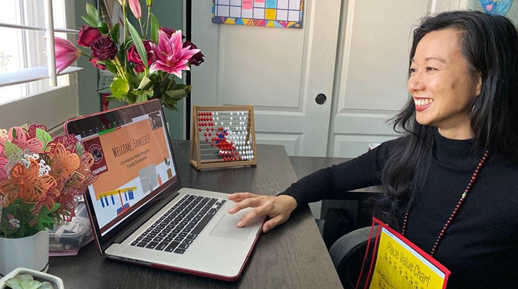 Dr. Cathery Yeh sitting at her computer during Community Math Program family orentation
