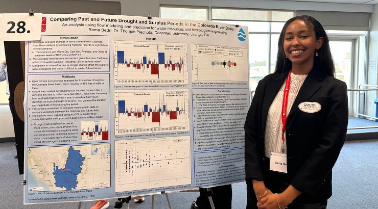A female engineering student standing in front of their presentation poster.