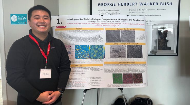 Male engineering students standing in front of their research poster.