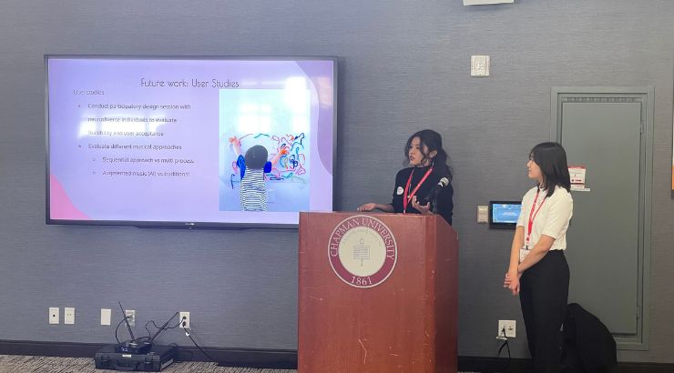 Two engineering student standing behind a podium giving an oral presentation of their research. 