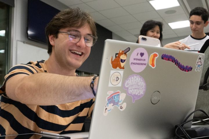 Student pointing to laptop computer