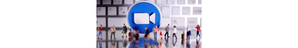 Screenshot of small figurines walking infront of the Zoom logo.