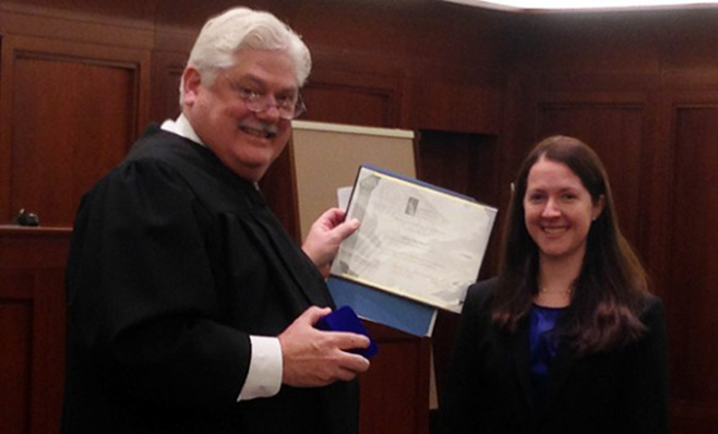 Ali Bollbach receiving Excellence Award from judge