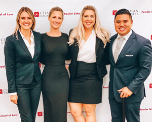 Three female and one male law student in suits