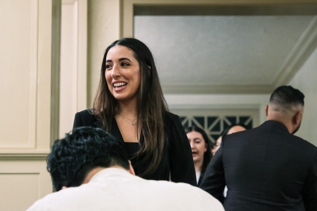 A Chapman Law graduate smiles waiting for Judge Vu's signature