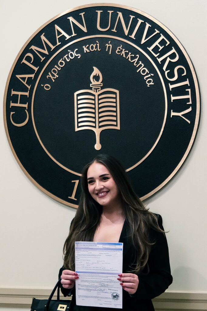 Rylee Watkins poses under the Chapman seal