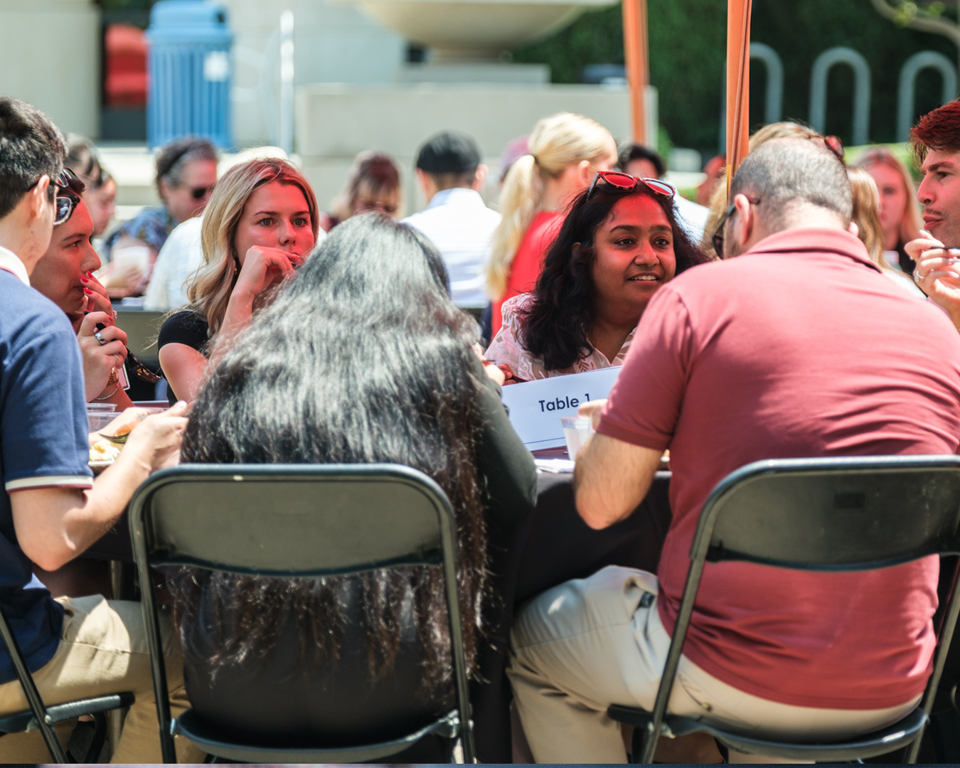 Photo of a professor in discussion with students over lunch