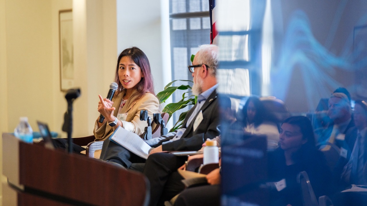A female panelists gesticulates while in discussion during her panel.