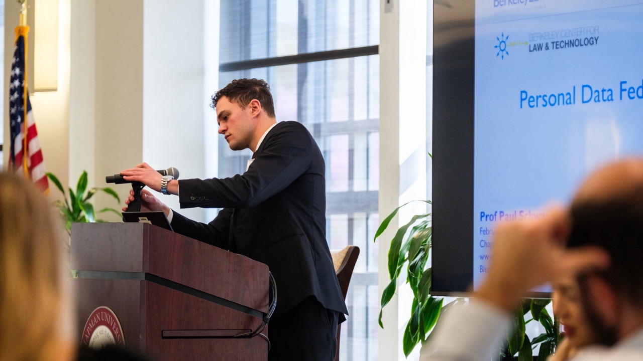 Chapman Law Review Editor-in-chief adjusts the microphone at the podium, prior to the keynote address.