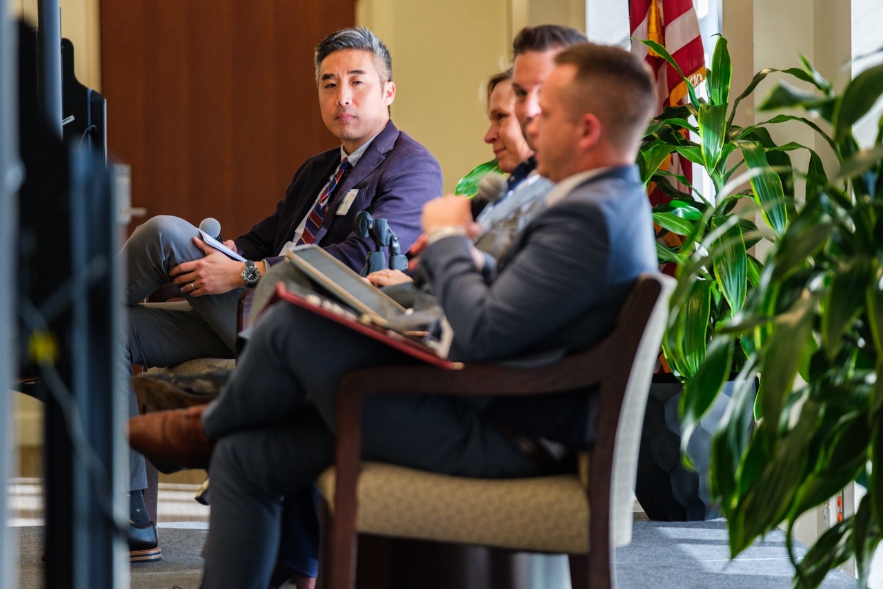 four panelists sit on stage in discussion during their panel session.