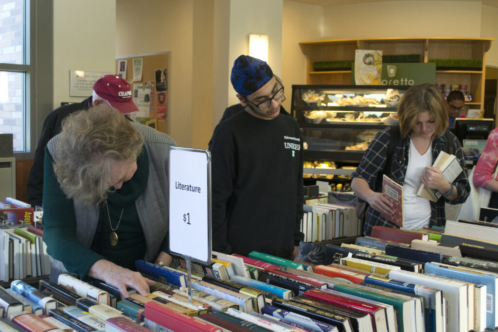 People searching through books for sale.
