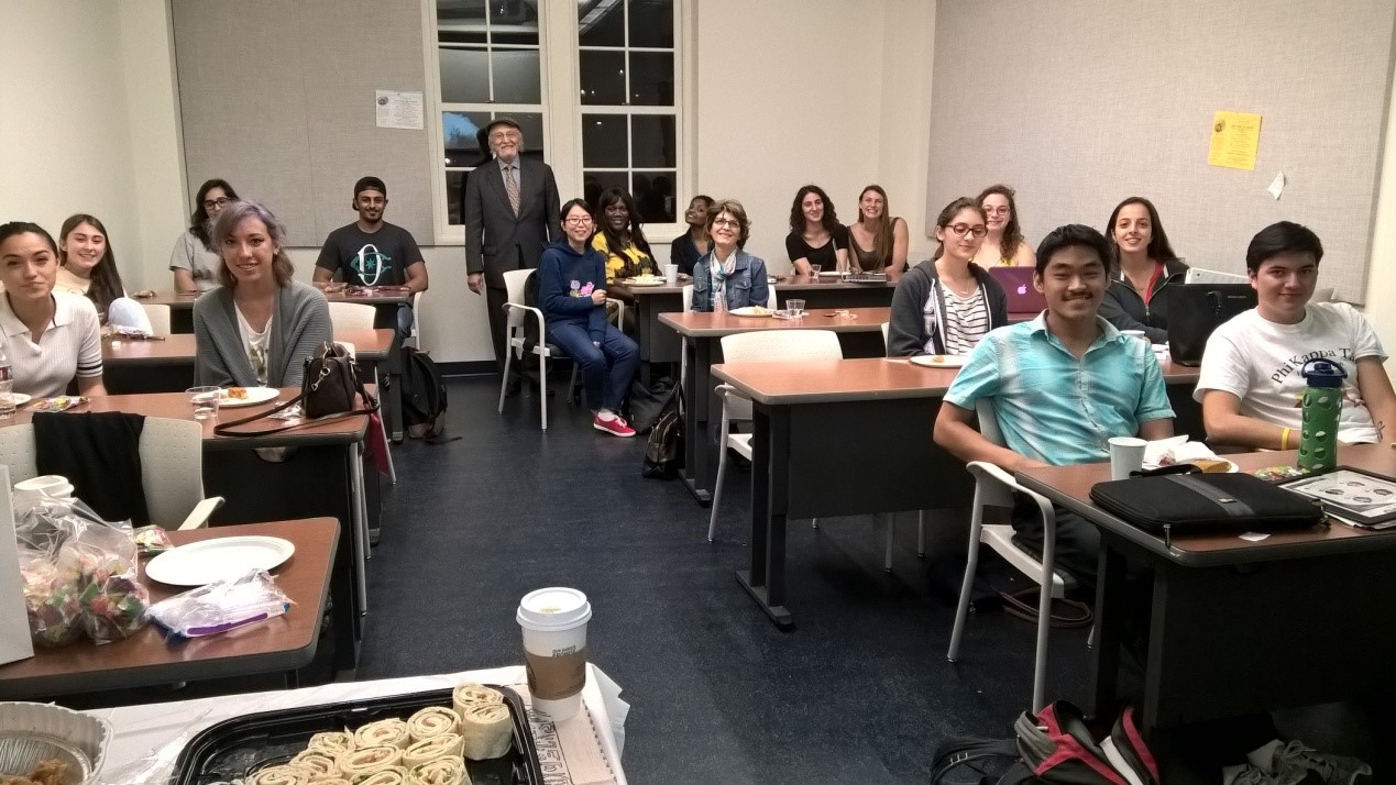Group of people in classroom, seated at desks.
