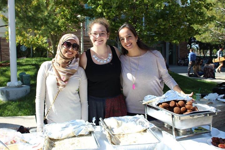 Group of people at food table.