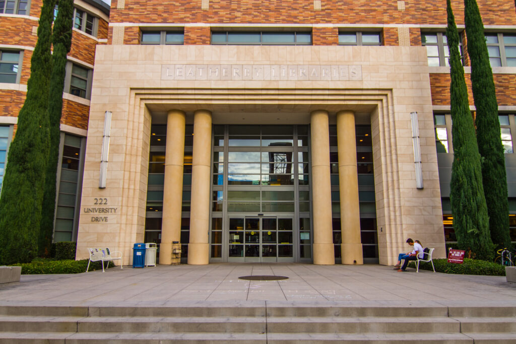 Exterior shot of a building, with a stage in front of a large door framed by pillars