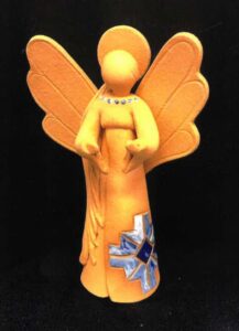A small ceramic figurine of an angel, in Native American-styled garb.