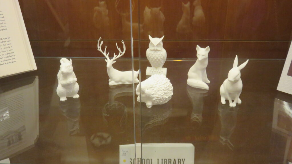 Six small white 3D-printed figurines of animals - a squirrel, a deer, a hedgehog, an owl, a fox, and a rabbit