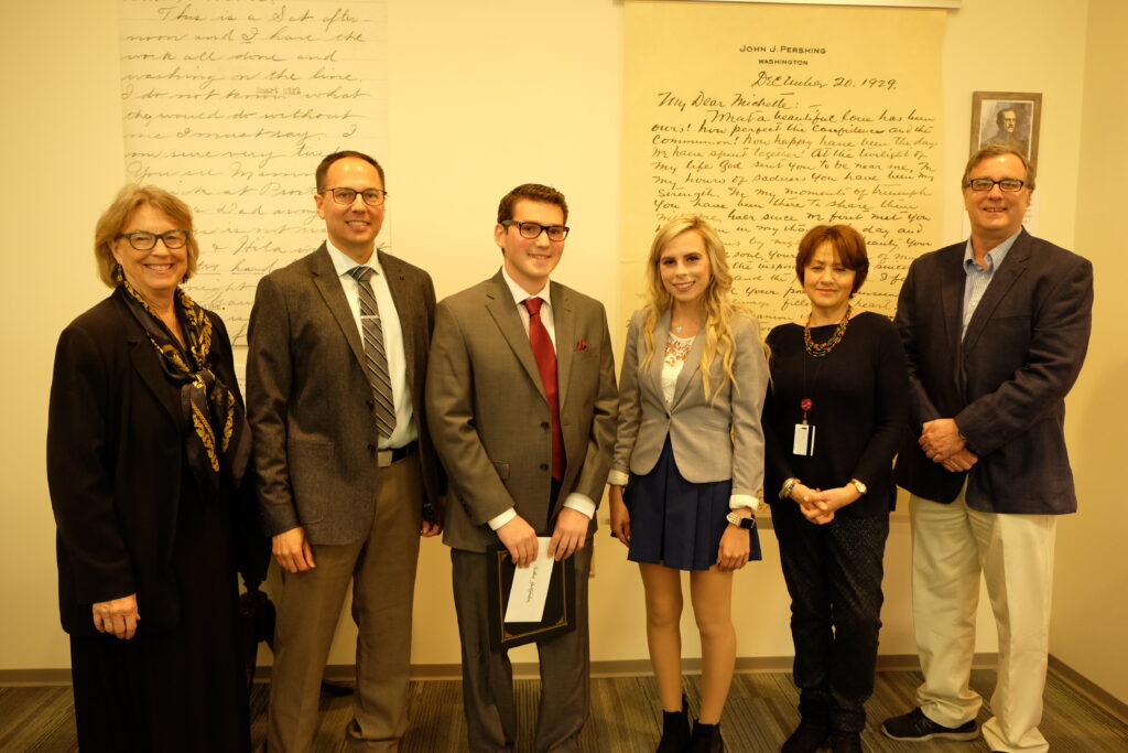 Two college students, one male and one female, are flanked by four staff/librarians.