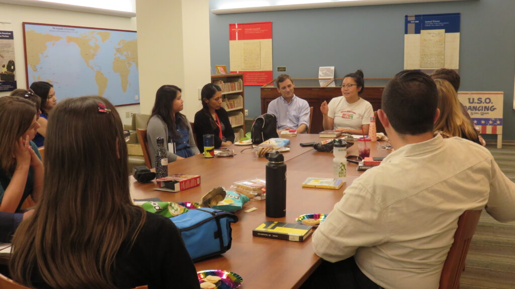A group of people sitting at a table having a conversation