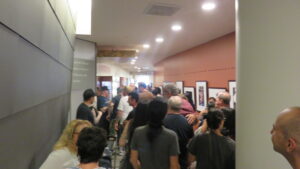 A crowd walks through a hallway