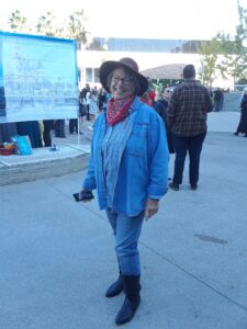 A woman wearing a cowgirl costume stands posing