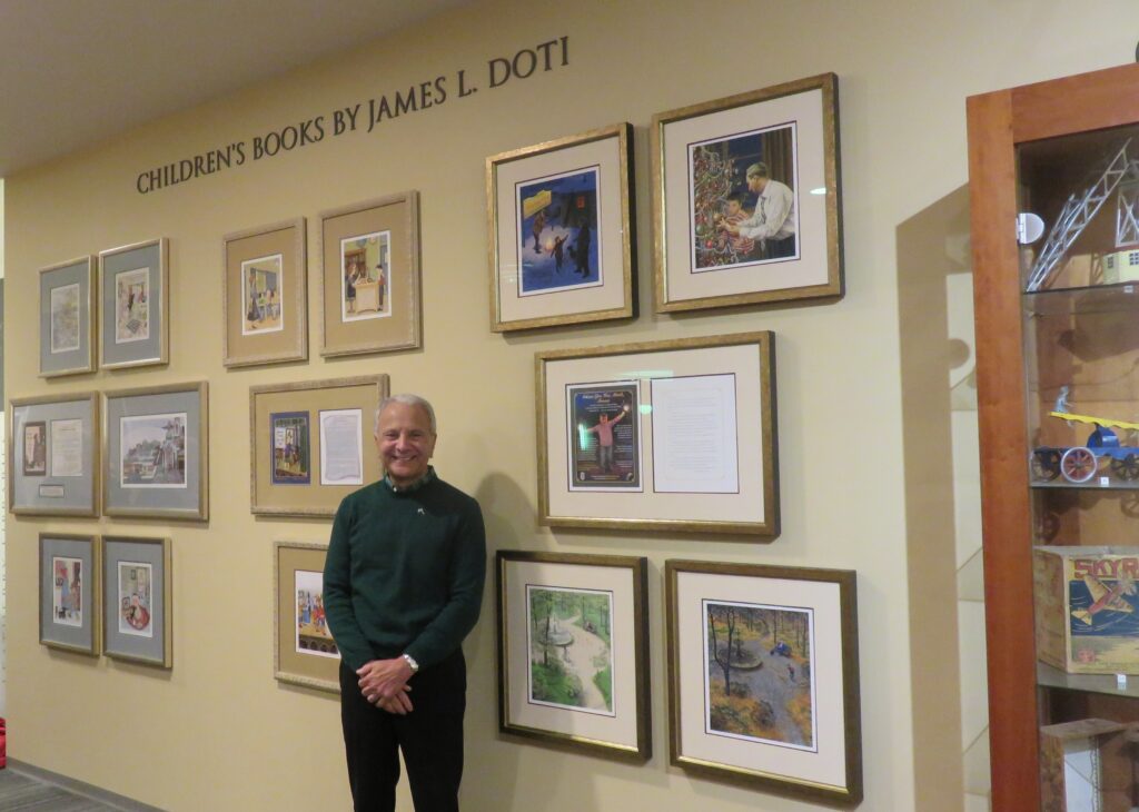 President Doti stands in front of the new Children's Books By James L. Doti wall