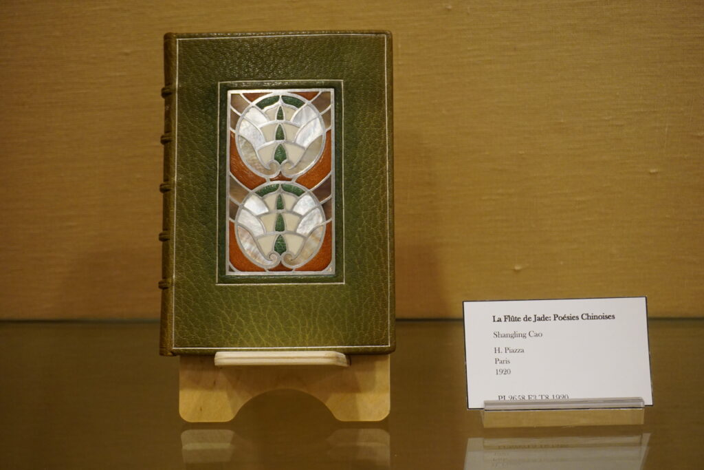 Close-up of a book with a detailed green cover with inlaid mother-of-pearl designs