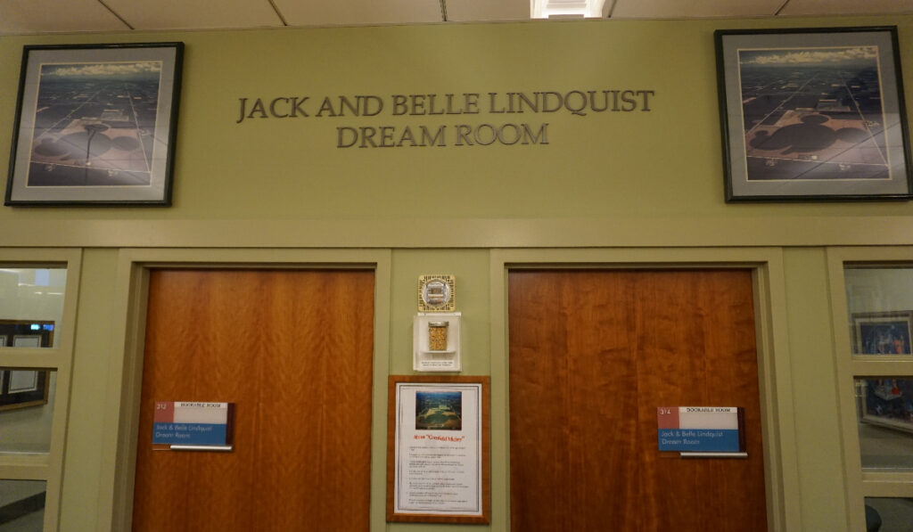 Two doors, with a sign reading "Jack and Belle Lindquist Disney Dream Room" above them, with the materials referenced in the post on display between the doors.