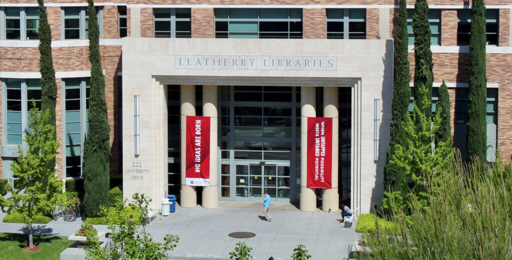 Exterior photograph of the Leatherby Libraries, with the name of the library in focus across the top of the doors.