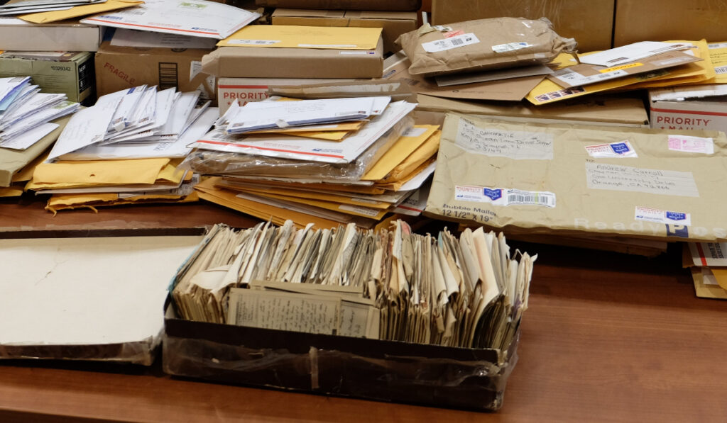 A table covered in envelopes, boxes, and packages