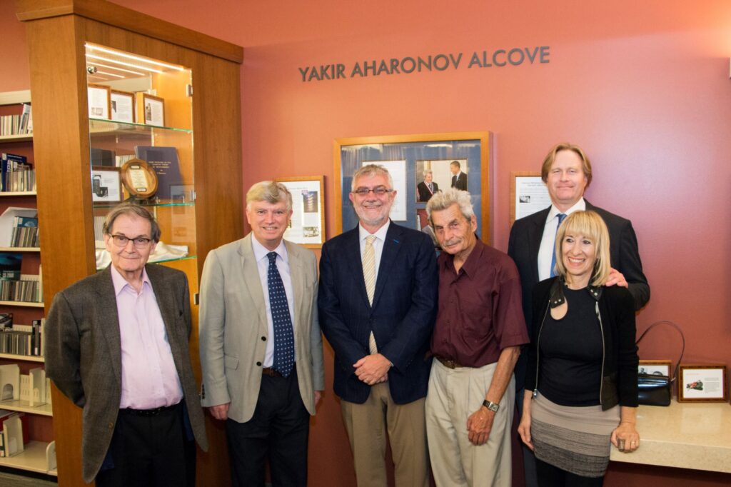 A group of six men and women stand posing for the camera.