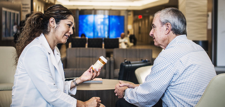 A pharmacist explains the drugs she's prescribing to a patient.
