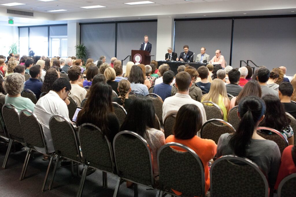 The crowd and panel at the Prop 37 debate.