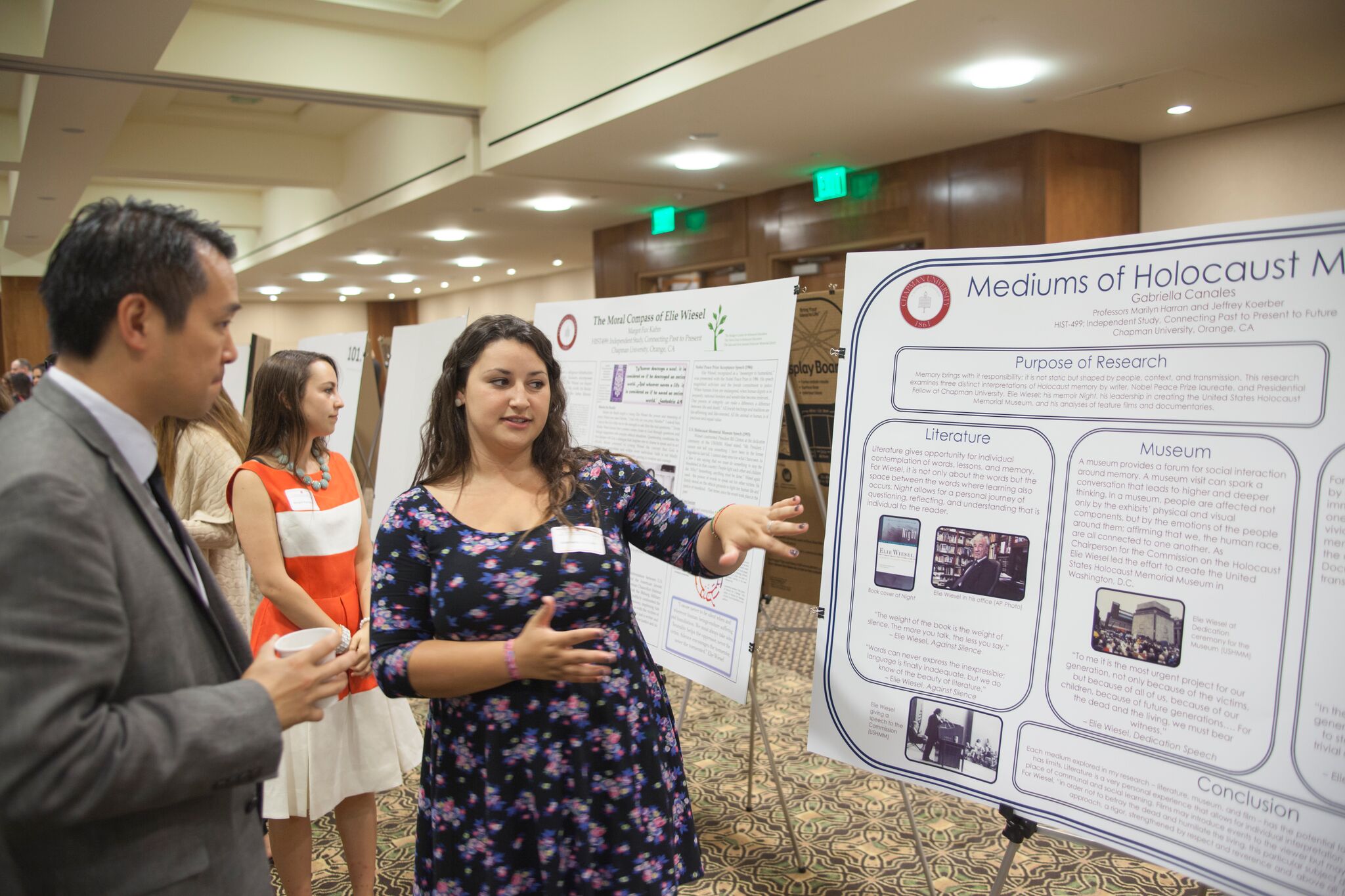 Undergraduate presenting research to Dr. Chris Kim at Student Scholar Symposium poster session