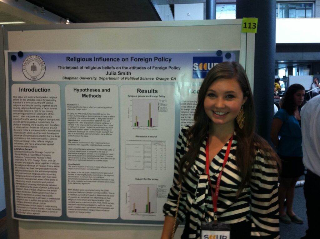 Woman smiling next to presentation board.