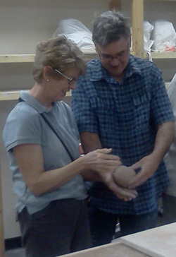 Man and woman holding ceramics.